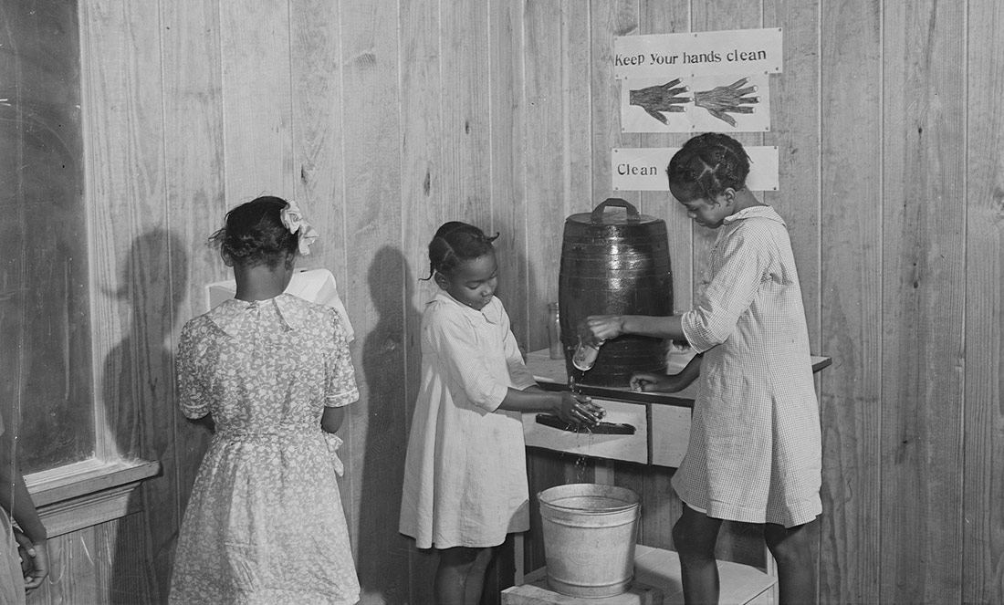 Nenes rentant-se les mans al racó de la neteja. Georgia, 1939