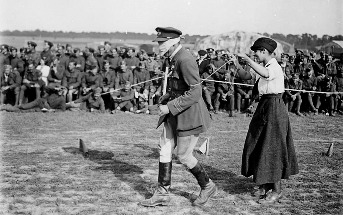 Un oficial de la RAF amb els ulls embenats i una infermera participant en una cursa. Rang du Fliers, 1918 | Imperial War Museum | Domini públic