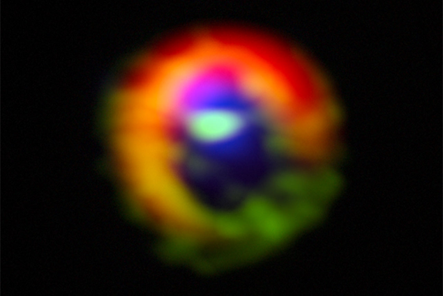 Observación real ALMA de HD142527 en color falso. Muestra los elementos distintivos de este disco protoplanetario: el vórtice con concentración de polvo (en rojo) y los flujos de material posiblemente canalizados por planetas en formación. Casassus et al. 2013, publicado en la revista Nature.