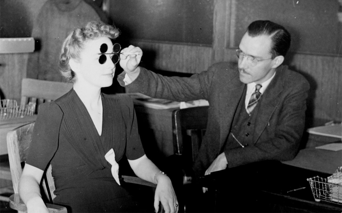 A DMV employee gives an eye exam, c.1933