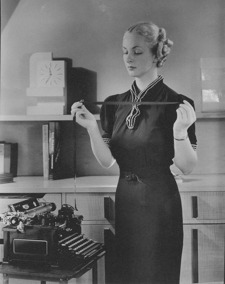 Mujer sosteniendo cinta de máquina de escribir, c. 1930s