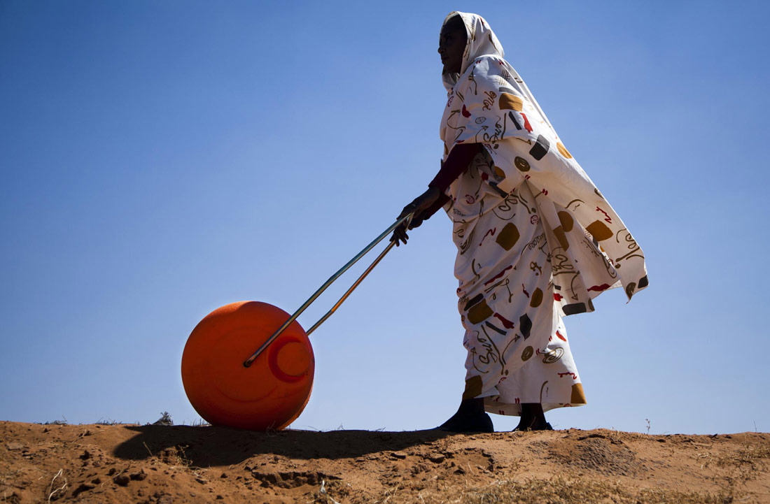 Una dona empeny un rodet d'aigua a El Fasher. Darfur, 2011