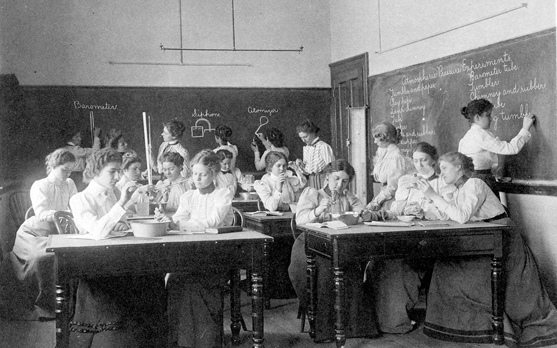 Grupo de mujeres jóvenes que realizan experimentos de presión atmosférica mientras estudian ciencias en la escuela normal. Washington, D.C., 1899