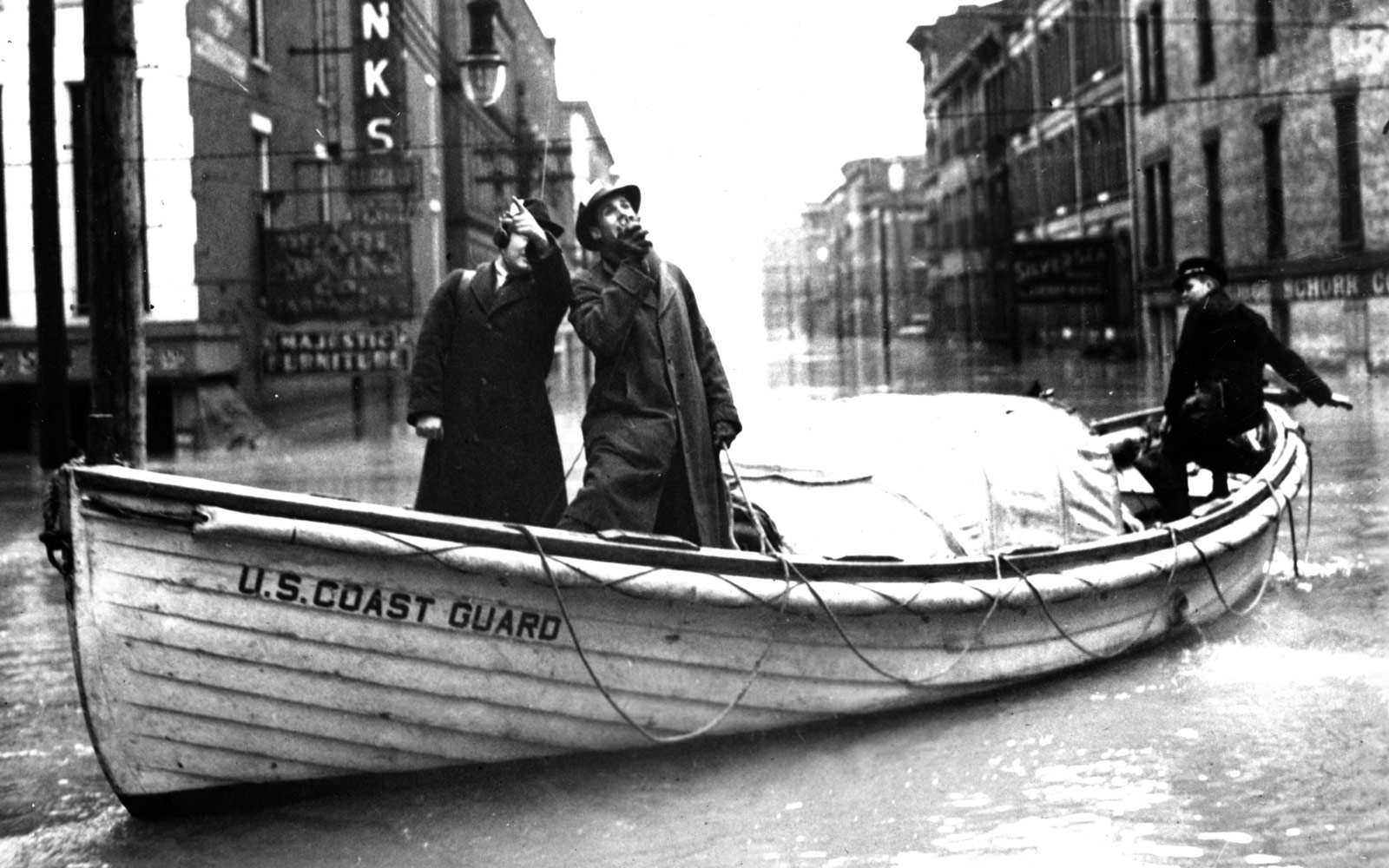 La Guardia Costera transporta reporteros de radio que detallan la devastación de la inundación. Ohio, 1937.