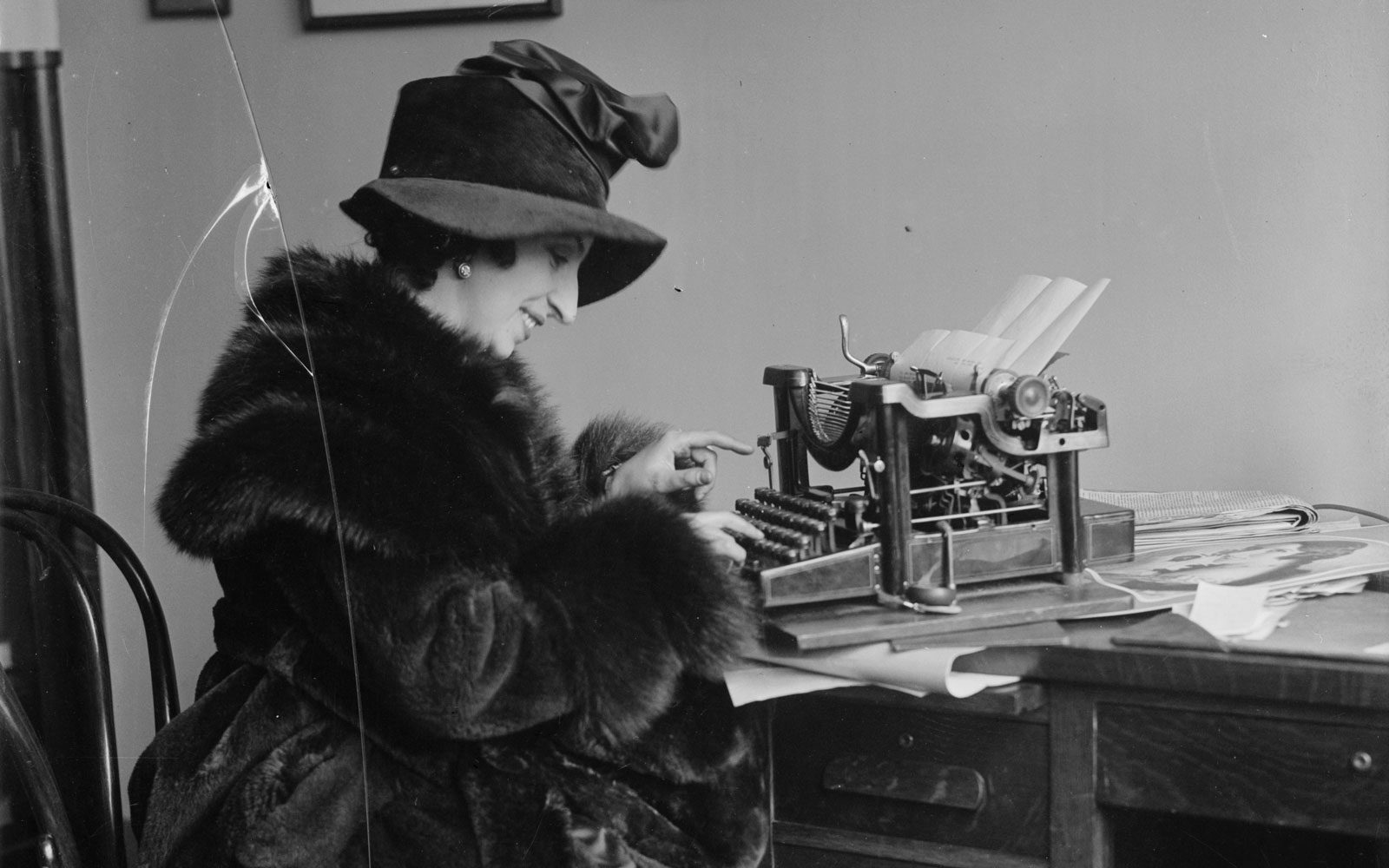 Amelita Galli-Curci seated at desk using typewritter, c. 1920