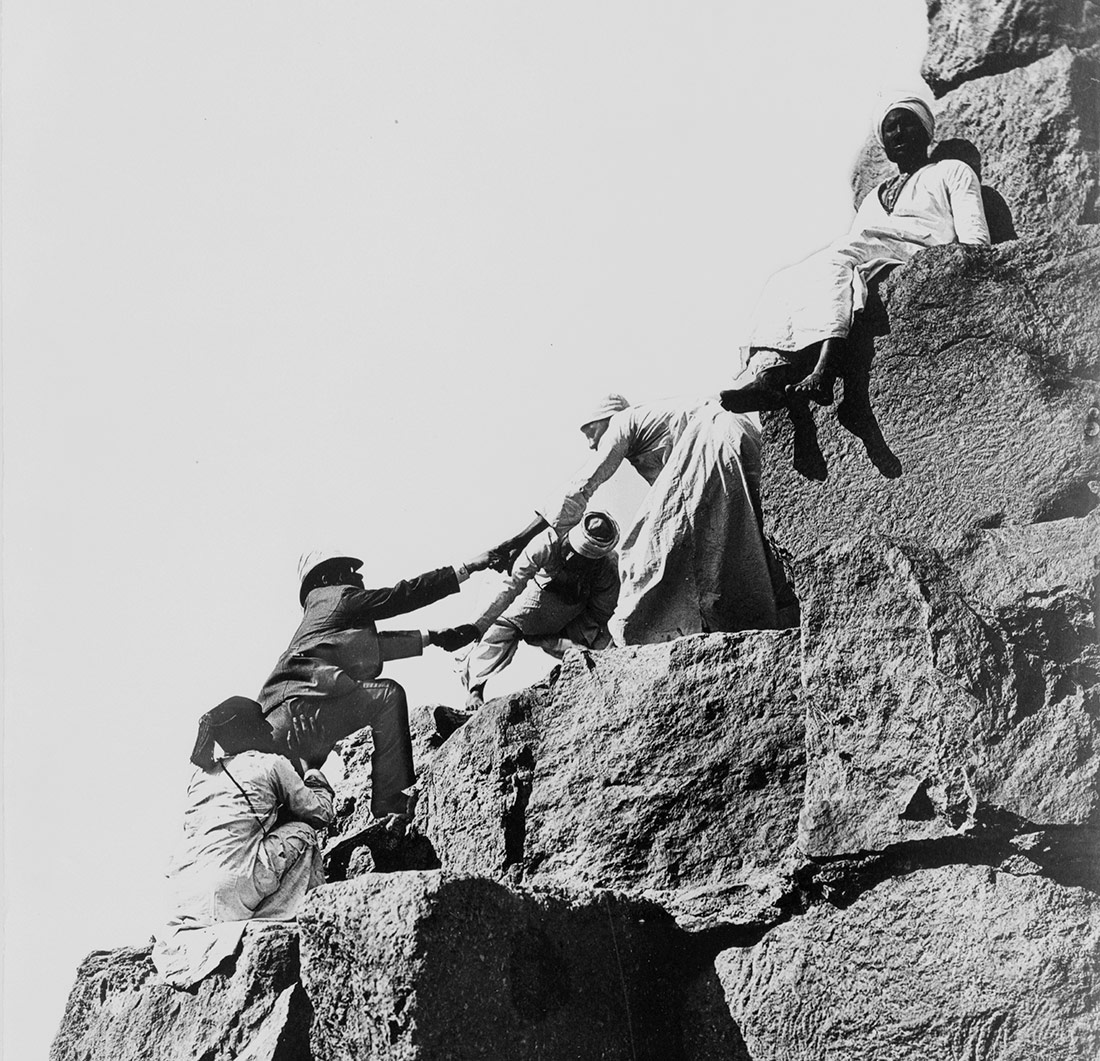 Turista ayudado a subir a la gran pirámide por hombres egipcios. Egipto, 1870-1880