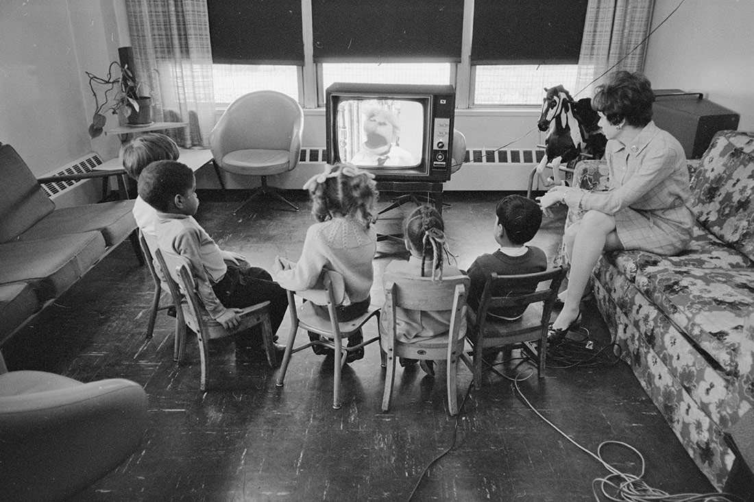 Woman and children watching television. 1969
