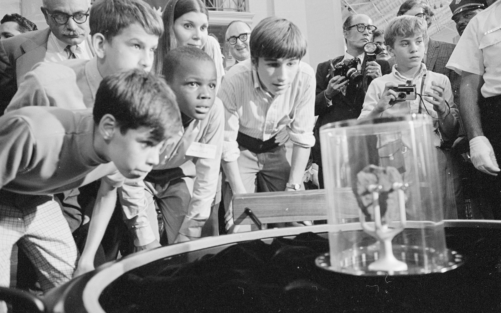 Una multitud de visitantes miran una muestra lunar expuesta en el Arts and Industries Building. Nova York, 1970
