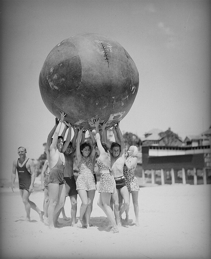 Un grup de persones aixecant una pilota inflable gegant. Cronulla, Austràlia, 1939