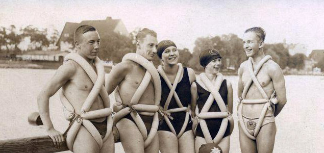 A group of youngsters tied a bike tyre around the body as a swimming aid. Germany, 1925.