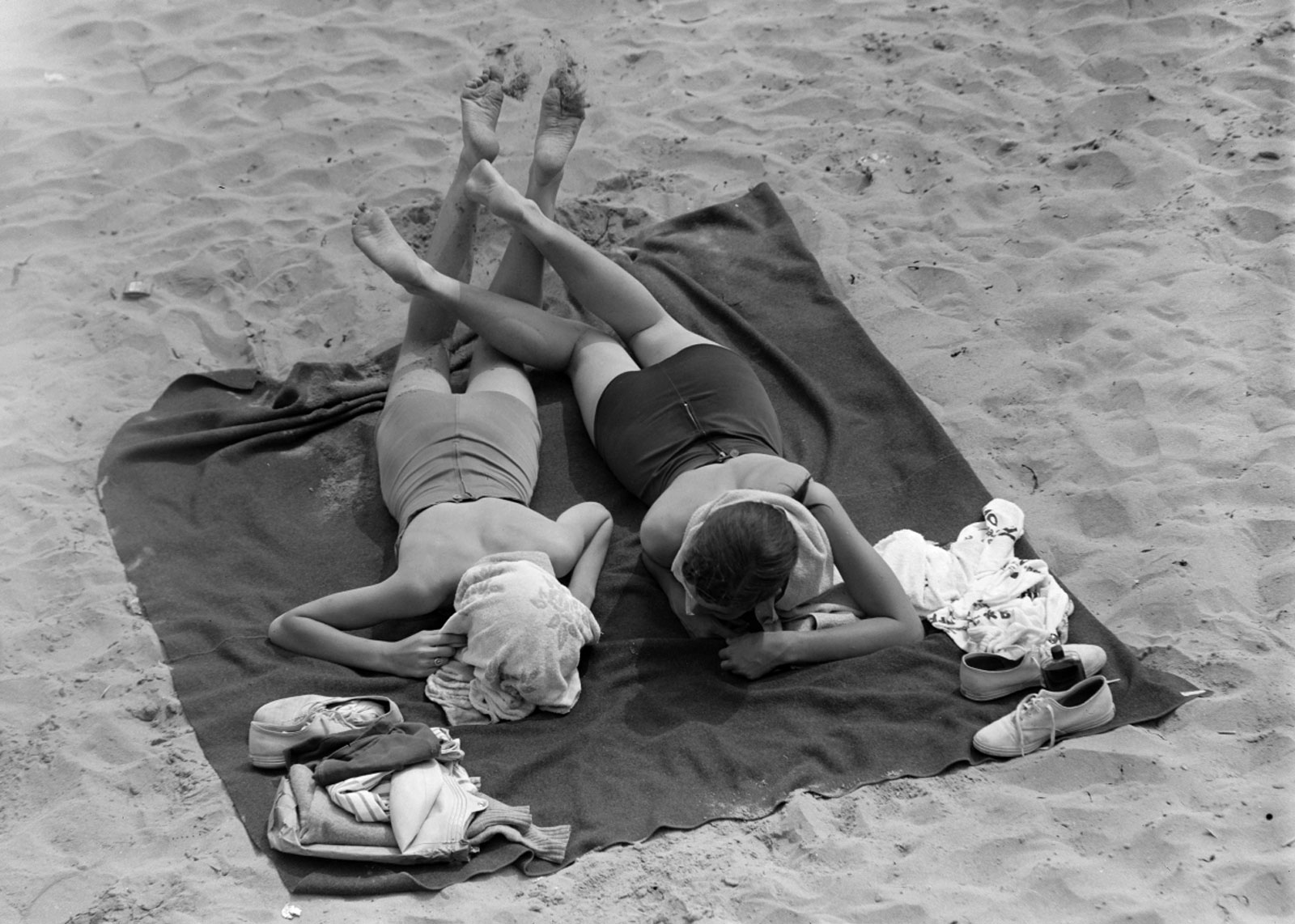 Two girls sunbathing at the beach.
